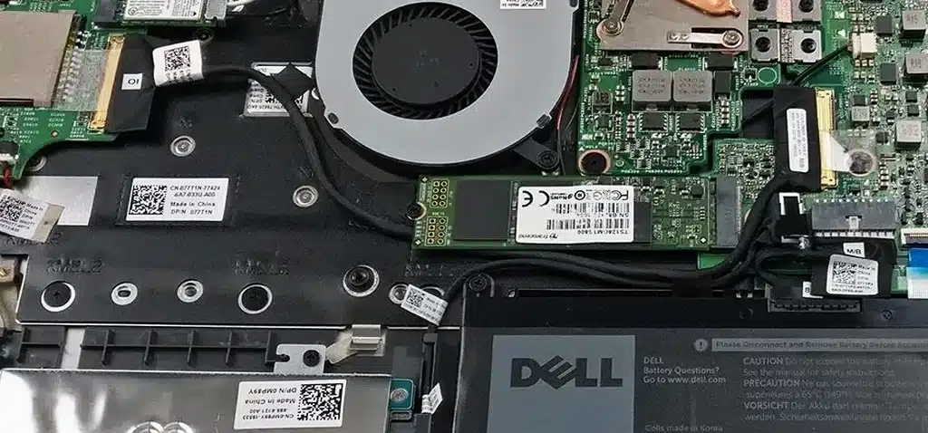 Dell laptop internals with SSD and fan, indicating repair signs