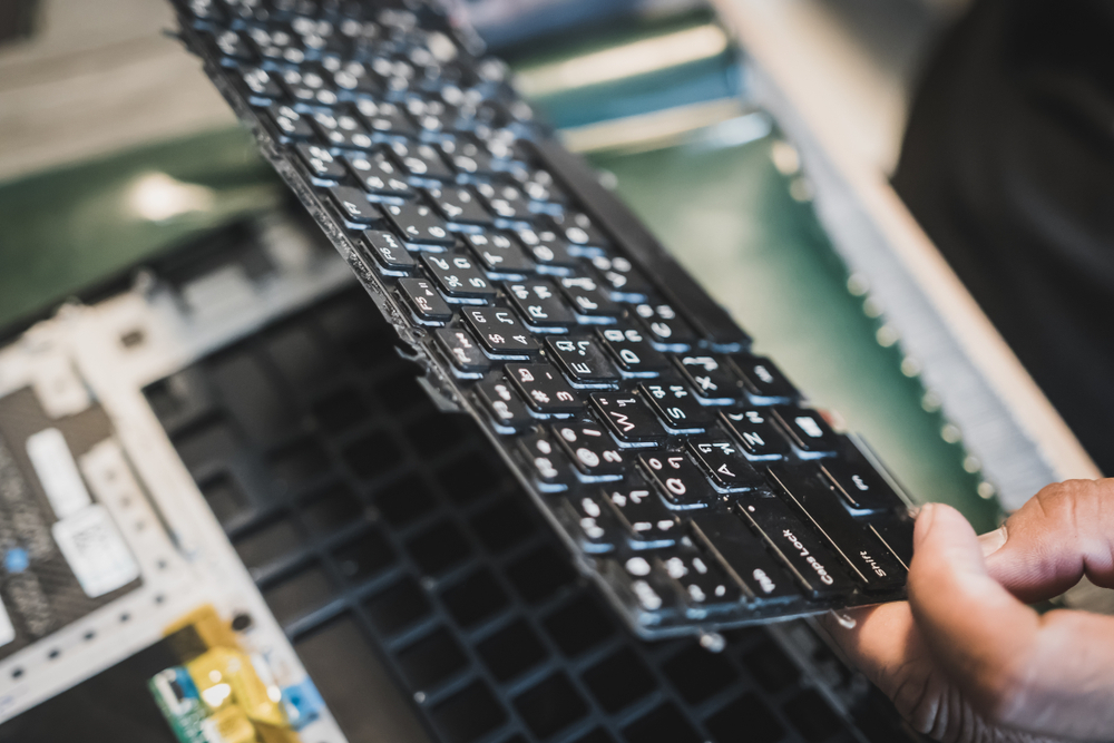 Laptop keyboard being removed for repair or replacement